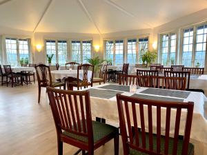 a dining room with tables and chairs and windows at Tokeryds Herrgård in Jönköping