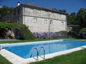 uma piscina em frente a um edifício de pedra em Casa De Carcavelos em Cabeceiras de Basto