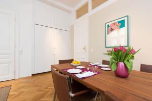 ein Esszimmer mit einem Holztisch und Stühlen in der Unterkunft Rosa Linde - Comfort Rooms in Wien