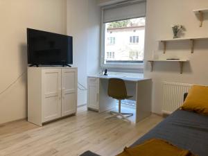 een slaapkamer met een bureau met een televisie en een bed bij Apartament Prusa in Lublin