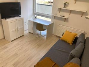 een woonkamer met een bank en een bureau bij Apartament Prusa in Lublin