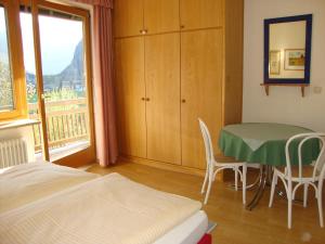 a bedroom with a bed and a table and a window at Haus Margrit Ferienwohnung in Sonnenlage in Golling an der Salzach
