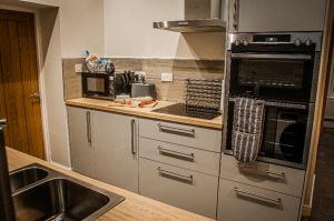 una cocina con electrodomésticos de acero inoxidable y fregadero en Log cabin en Coventry