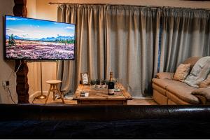 uma sala de estar com um sofá e uma televisão de ecrã plano em Log cabin em Coventry