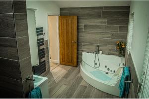 a bathroom with a large tub in a room at Log cabin in Coventry
