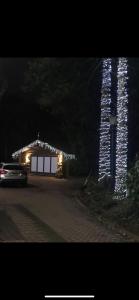 uma casa com luzes de Natal numa garagem à noite em Log cabin em Coventry