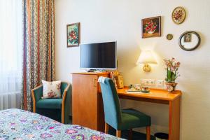 TV a/nebo společenská místnost v ubytování Tante ALMA's Kölner Hotel
