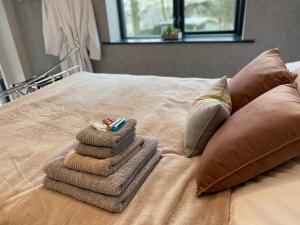 a pile of towels sitting on top of a bed at Room with a View in Holmfirth