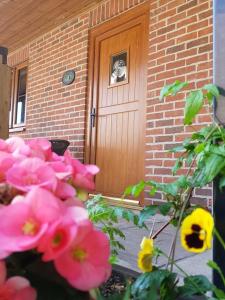 ein Haus mit rosa Blumen vor einer Tür in der Unterkunft Cripps Farm Holiday Lets in Cote