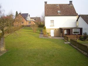 um quintal com uma casa branca e uma cerca em Ferienhaus und Ferienwohnung Knappstein em Möhnesee