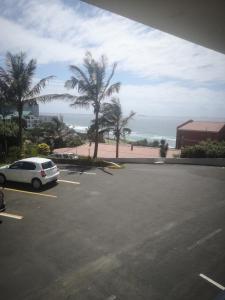 a car parked in a parking lot near the ocean at 106 Umdloti Resort in Umdloti