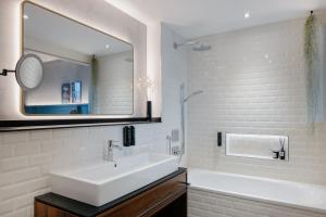 uma casa de banho branca com um lavatório e um espelho em Downtown Apartments Mitte-Wedding em Berlim