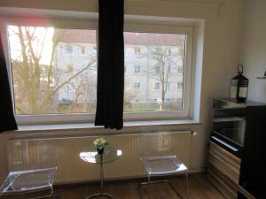 einen Tisch und zwei Stühle vor einem Fenster in der Unterkunft Studio Apartment - Messe Nord in Hannover