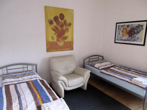 Zimmer mit 2 Betten, einem Stuhl und einem Bild in der Unterkunft Studio Apartment - Messe Nord in Hannover