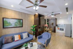 Il comprend un salon avec un canapé bleu et une cuisine. dans l'établissement BOM HOMES- Vinhomes Times City- Service Apartment, à Hanoï