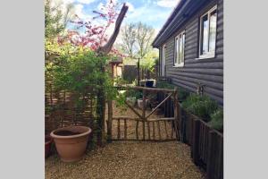 a gate to a garden outside a house at Norfolk Cabin in King's Lynn