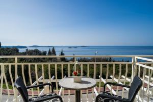 een tafel en stoelen op een balkon met uitzicht op de oceaan bij Villa Samba in Mlini