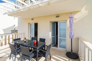 a dining room with a table and chairs and an umbrella at Villa Samba in Mlini