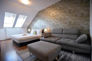 a living room with a bed and a couch and a bed and a couch at Corner Apartman Eger in Eger