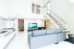 a living room with a couch and a staircase at B BASE KOURI iSLAND in Kouri