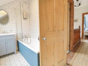 y baño con bañera azul y lavamanos. en 4 Tan Y Bryn Road, en Llandudno 23 fotos más