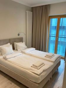 duże łóżko w pokoju z dużym oknem w obiekcie Mennica Residence Hotel Apartments w Warszawie