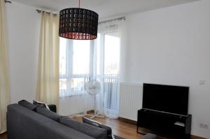 a living room filled with furniture and a tv at Prudentia Apartments Kłobucka in Warsaw