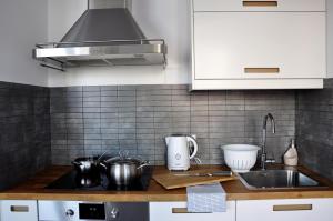 a kitchen that has a sink and a stove at Prudentia Apartments Kłobucka in Warsaw