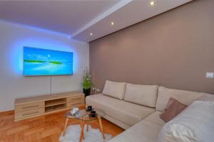 a living room with a white couch and a tv at Zadar Dream Holiday Apartment in Zadar