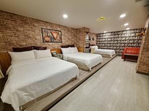 新竹市にあるBin Chen Business Hotelのレンガの壁、ベッド2台が備わるベッドルーム1室が備わります。
