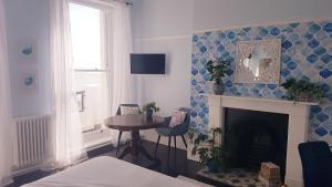 a room with a fireplace and a table and a window at The Bank Hotel & Bistro in Hastings