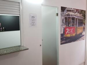 uma parede com uma televisão e uma imagem de um eléctrico em 7 Luz Hostel em Lisboa