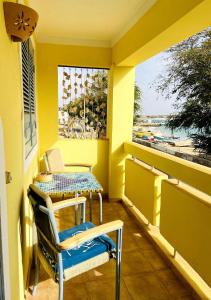 a balcony with a table and chairs and a window at Ca' Santa Barbara, Free Wi-fi, Sea view, Sal Rei, Boa Vista, Cape Verde in Sal Rei