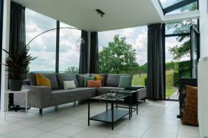 uma sala de estar com um sofá e uma mesa em Vakantiewoningen Hoeve Carpe Diem - Dalhem - Aubel - Voeren em Dalhem