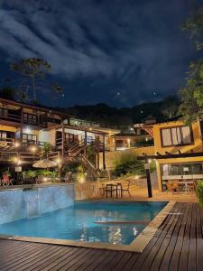 una piscina frente a un edificio por la noche en Hotel La Forêt & Beach Club, en Búzios