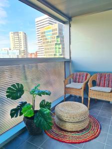 a balcony with two chairs and a table and a window at Fira Gran Via - Barcelona4Seasons in Hospitalet de Llobregat