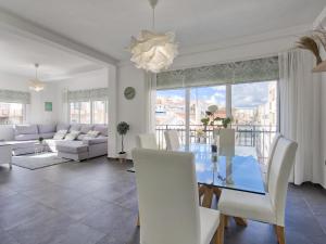 salon ze szklanym stołem i białymi krzesłami w obiekcie Sur Suites El Carmen w mieście Fuengirola