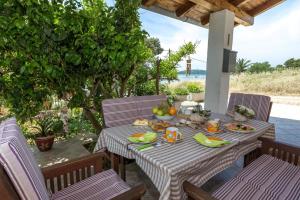 einen Tisch mit Obst auf der Terrasse in der Unterkunft Beachfront Holiday House Zita in Brgulje