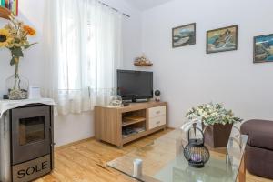 a living room with a television and a table at Beachfront Holiday House Zita in Brgulje