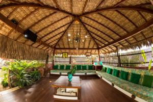 a large room with green seats and a wooden ceiling at Pousada Jurará e Vila Jurará in Atins