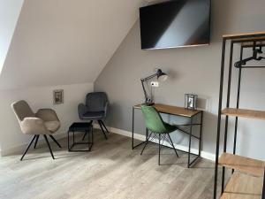 a room with chairs and a desk and a tv at Aparthotel Charlotten in Hannover