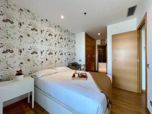 1 dormitorio con 1 cama y una pared con flores en Fira Gran Via - Barcelona4Seasons, en Hospitalet de Llobregat