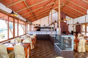 a restaurant with wooden ceilings and tables and chairs at Yantra Resort By Spree Ooty in Ooty