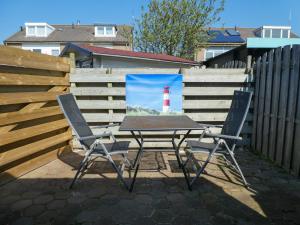 a table and chairs with a picture of a lighthouse at Studio de Aankomst in De Koog