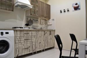 a kitchen with a washing machine and two chairs at Апартаменты Park & House 8 рядом с источником и парком in Essentuki