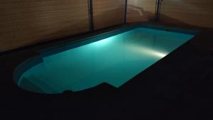 a swimming pool in a dark room with a blue light at Cabañas Antawara Uspallata in Uspallata