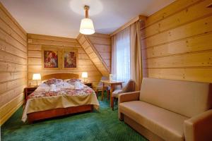 ポロニンにあるGóralski Gościniec & SPAのベッドルーム1室(ベッド1台、ソファ、テーブル付)