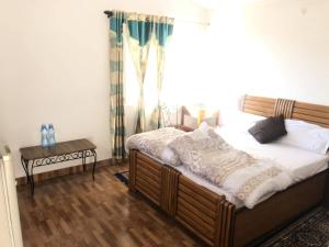 een slaapkamer met een groot bed en een raam bij White house in Nainital in Bhīm Tāl