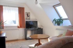 ein Wohnzimmer mit einem Sofa und einem Tisch in der Unterkunft Atelier Grünfink Ferienwohnung in Clausnitz