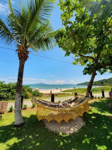 una hamaca colgada entre dos palmeras en una playa en Pousada dos Ingleses, en Bombinhas